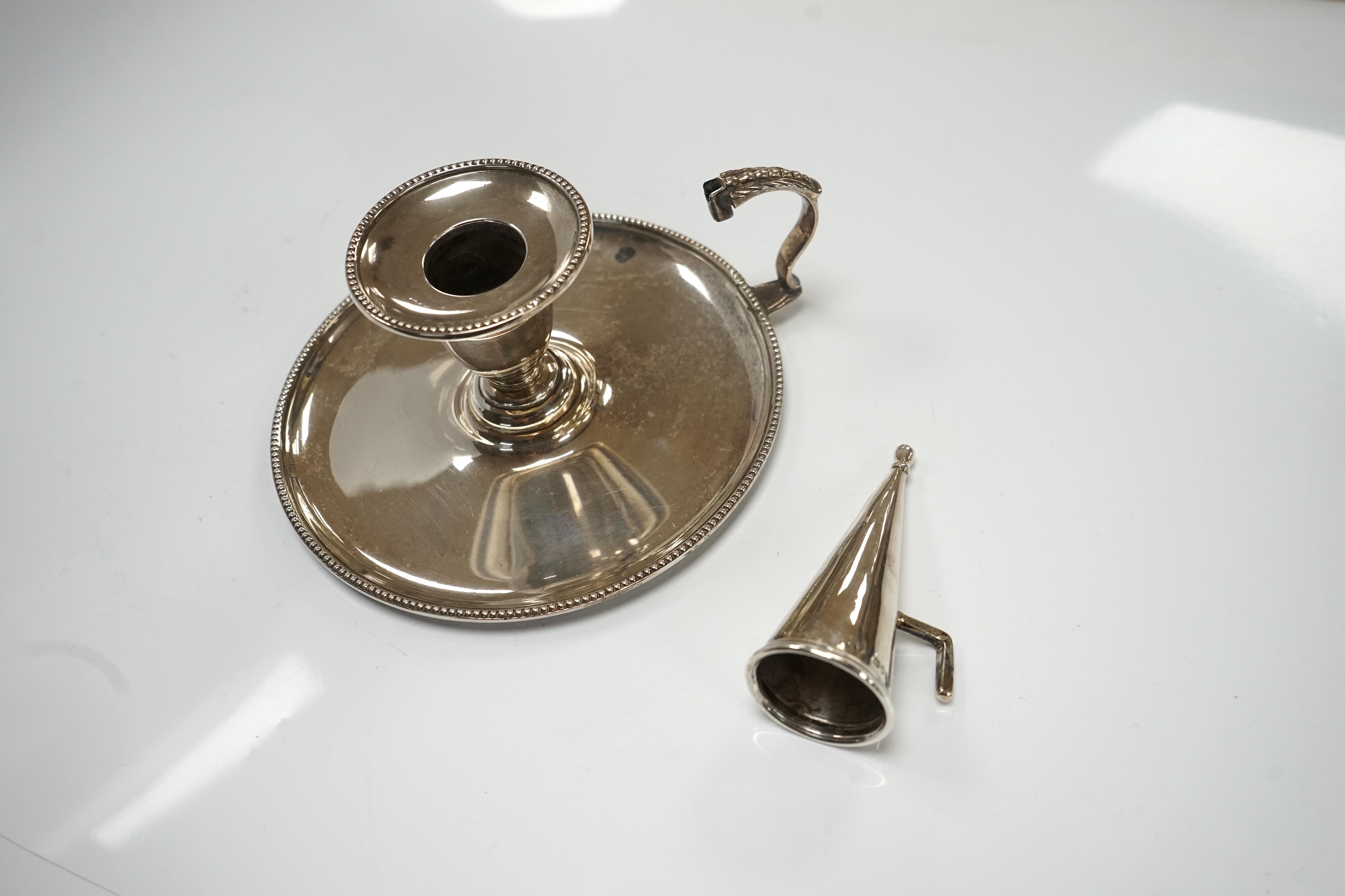 A Victorian silver chamberstick, Walker Knowles & Co, Sheffield, 1859, with later associated silver extinguisher, diameter 13.2cm. Condition - fair